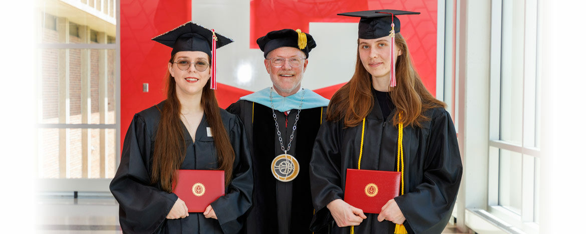 Central College president Mark Putnam poses for a photo with Central's first women engineering graduates.