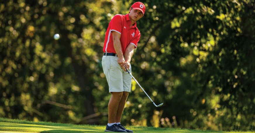 A Central College golfer lines up a chip shot.