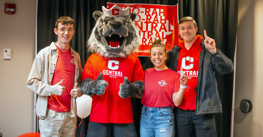 Central College students posing with Big Red, the school mascot.