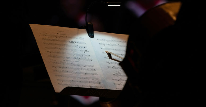 A photo of sheet music, looking over the shoulder of a musician.