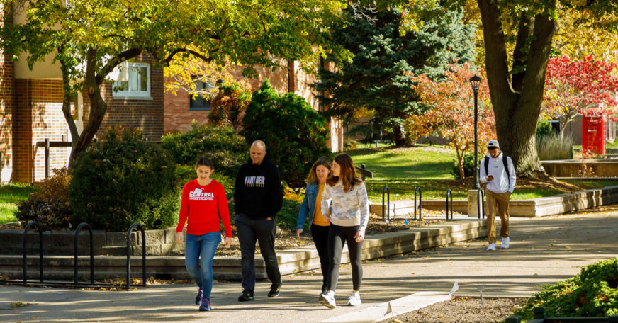 A Central College student leading a prospective student and her family on a tour of campus.