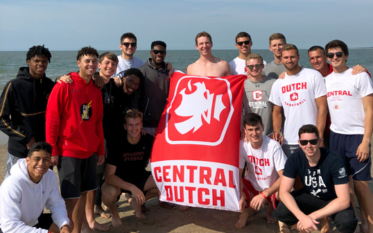 The Central College men's basketball team poses for a photo on the beach of the North Sea in The Netherlands.